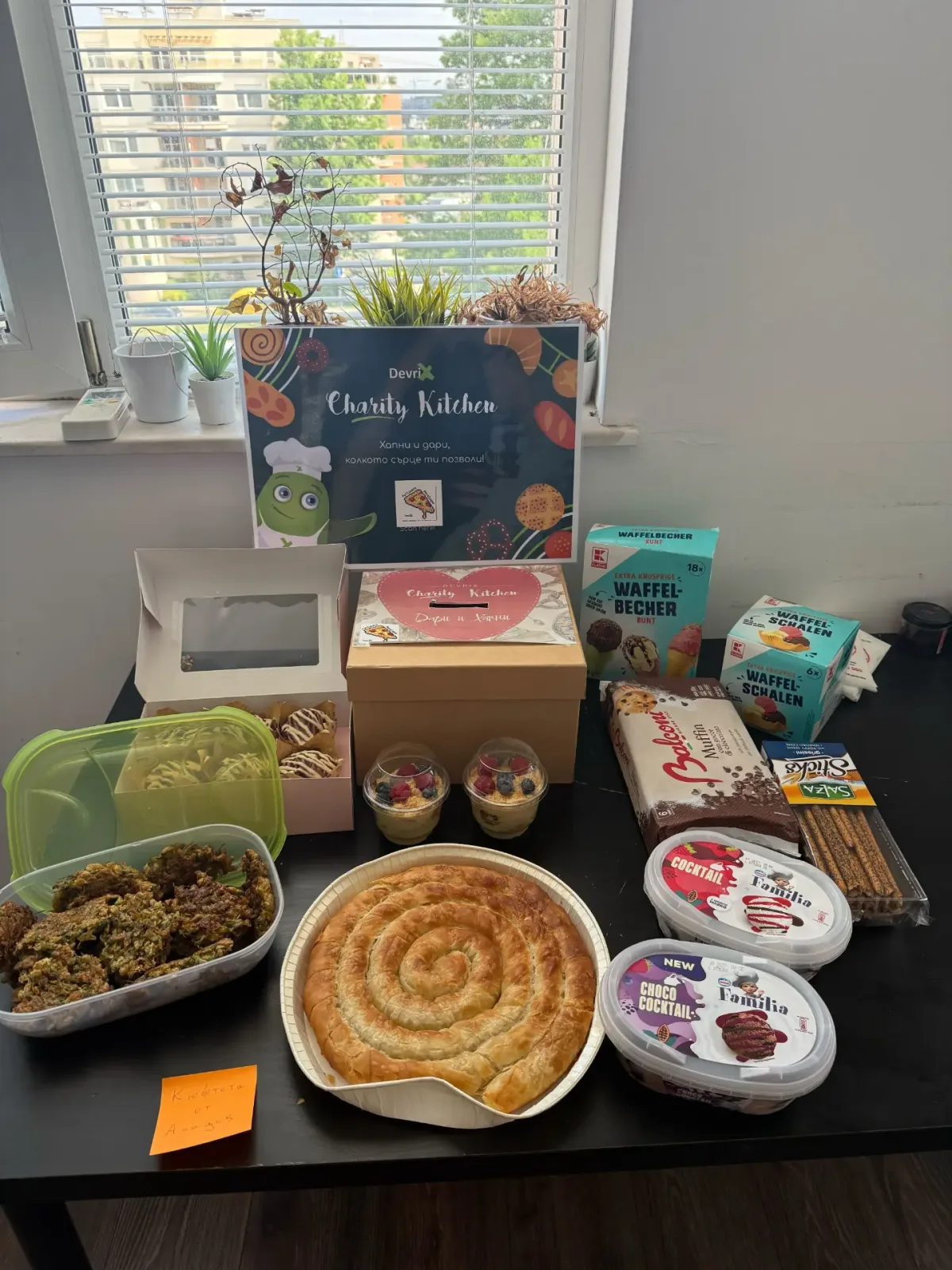 DevriX Charity Kitchen table with homemade food, pastries and a donation box