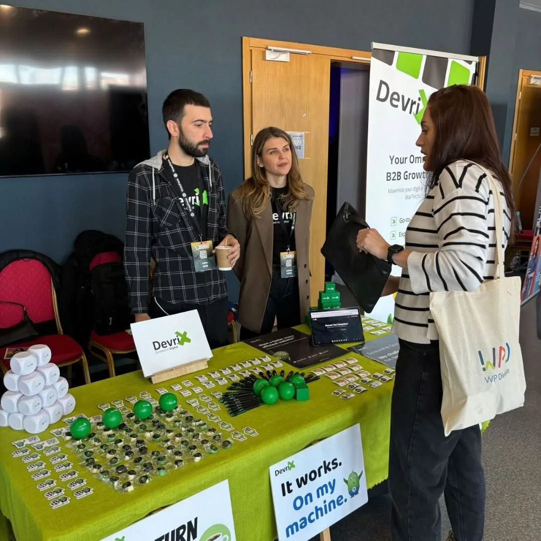 WordCamp booth with the team talking with an attendee