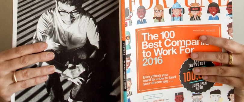 person holding a book entitled the 100 best companies to work for 2016